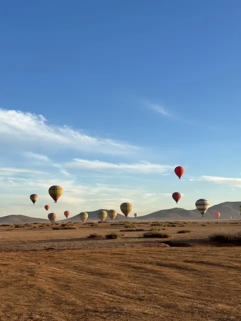 Volo in mongolfiera a Marrakech – Mongolfiere sopra la pianura di Marrakech con le montagne sullo sfondo